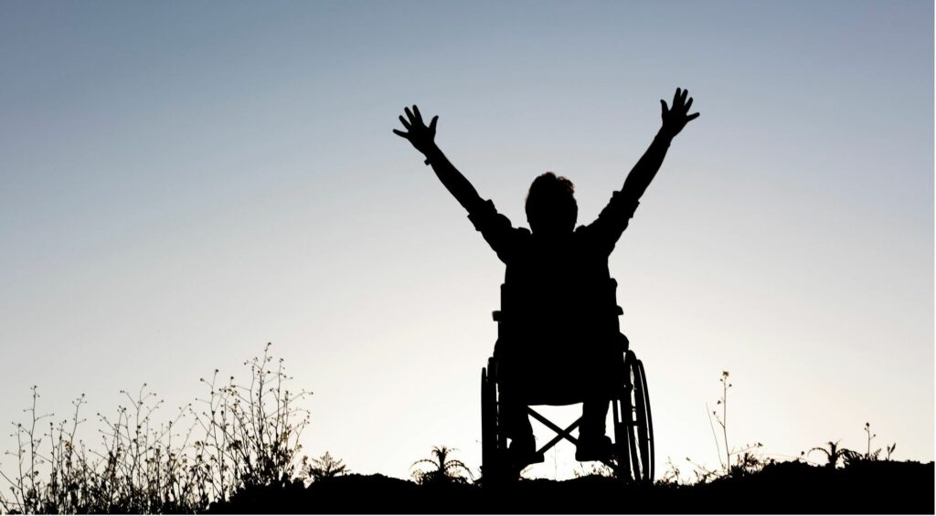 Wheelchair user rejoicing in silhouette
