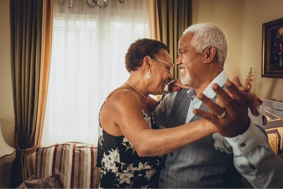 Older couple slow-dancing at home