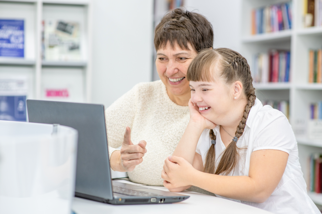 Young girl with adult carer on laptop