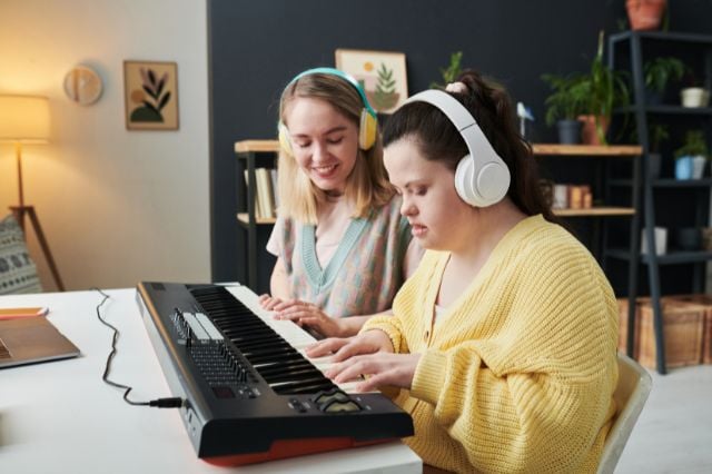 girl with down syndrome playing the keyboard with career 